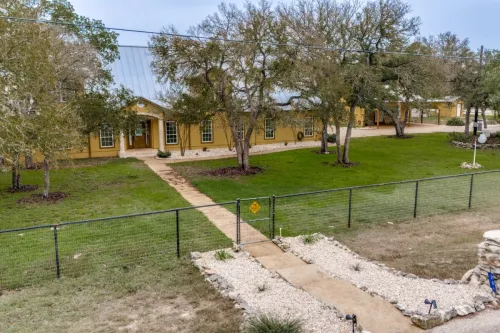 Luxury brick house featuring a large terrace, fire pit, and well-maintained garden.