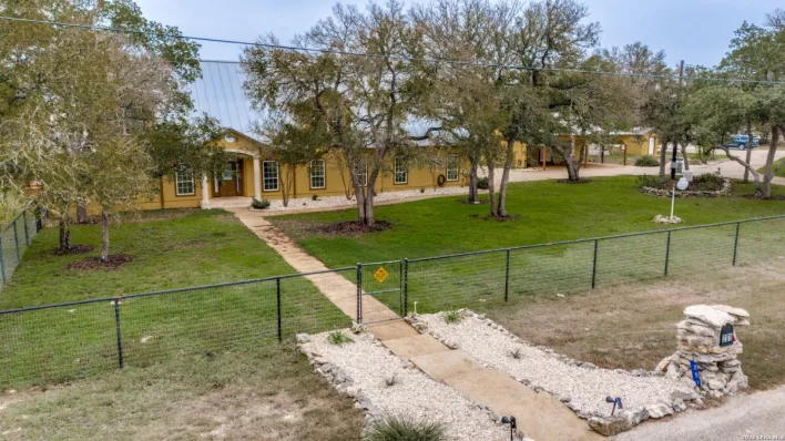 Luxury brick house featuring a large terrace, fire pit, and well-maintained garden.