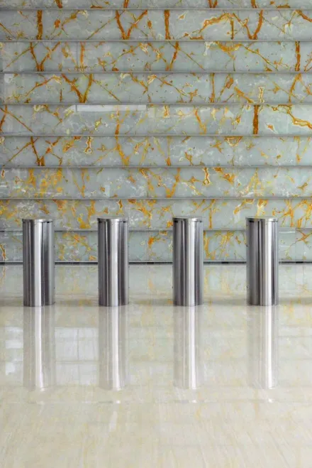 A sleek corporate lobby featuring marble walls, metal dividers, and glass windows for a sophisticated design.