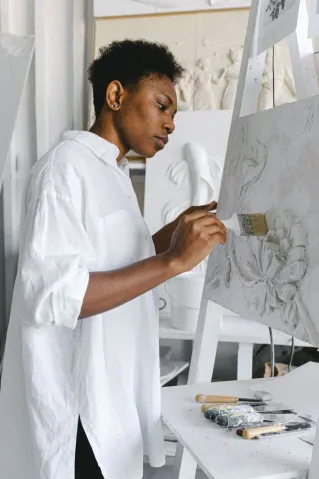 A talented artist immersed in creating a floral painting on canvas in a stylish studio.