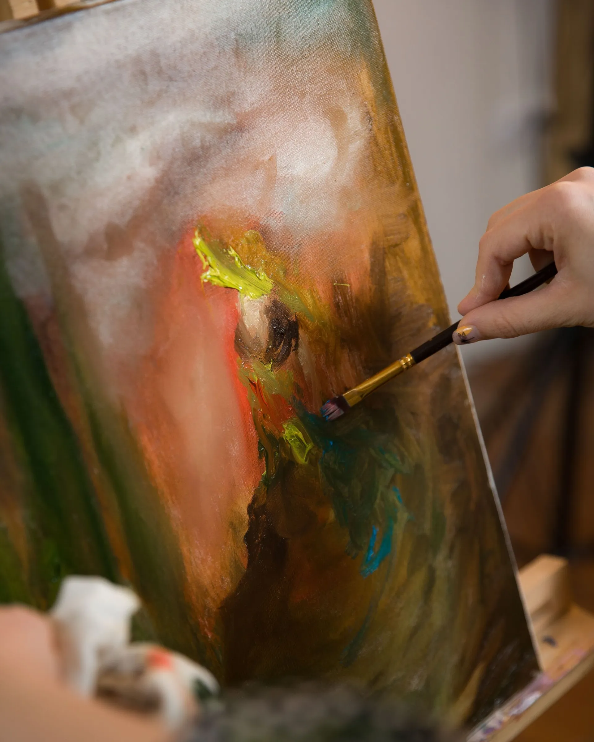 Hand painting vibrant abstract art on canvas with vivid brush strokes.