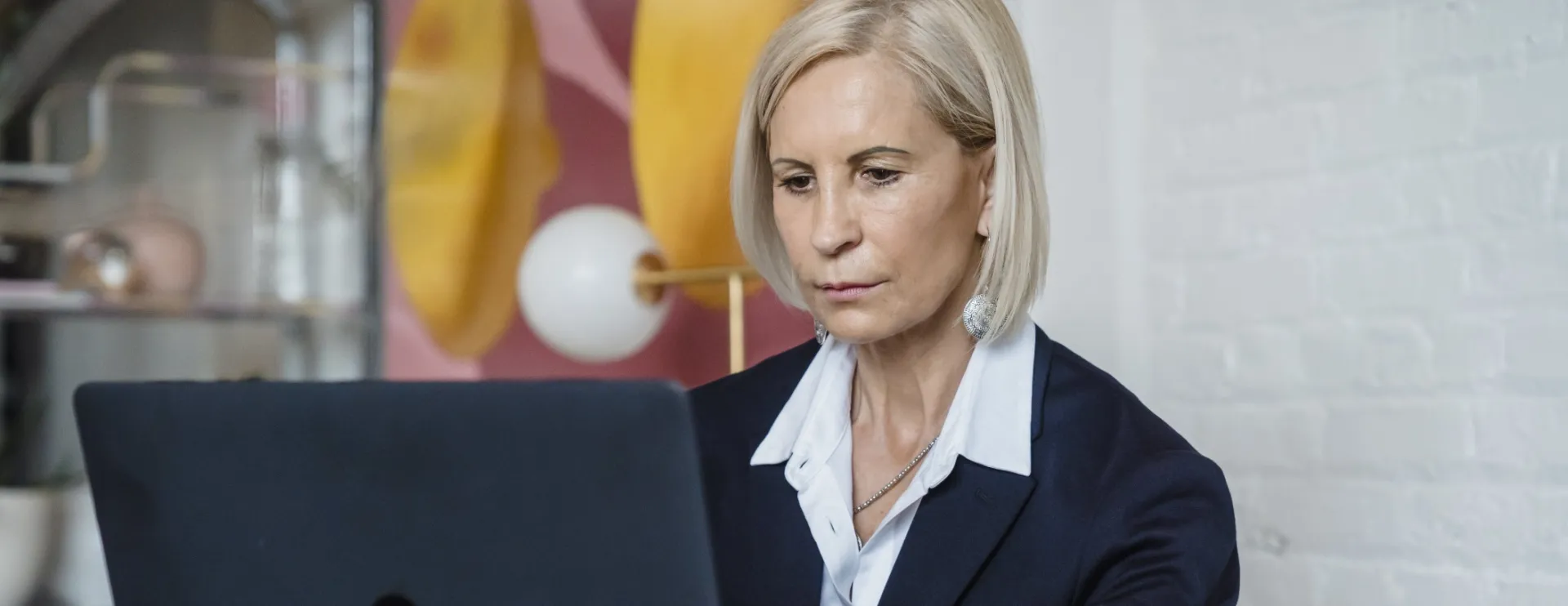 Elegant Mature Woman Sitting and Using Laptop