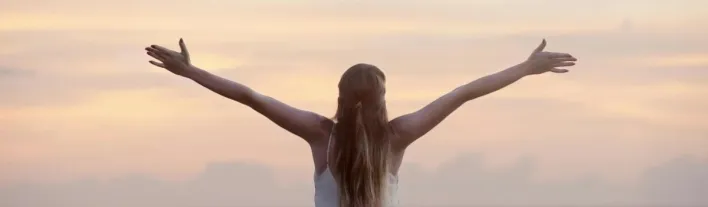 A woman enjoying a serene sunset on Unawatuna Beach, Sri Lanka, depicting peace and freedom.