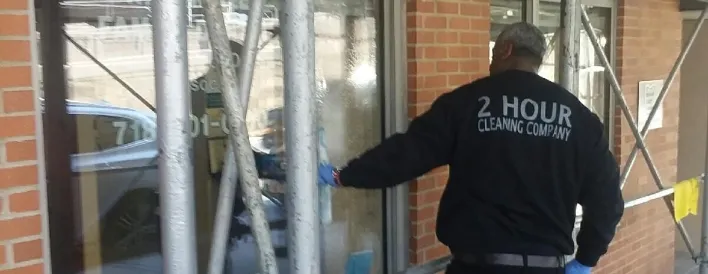 Man cleaning office window, ensuring a streak-free and spotless glass surface in a commercial workspace